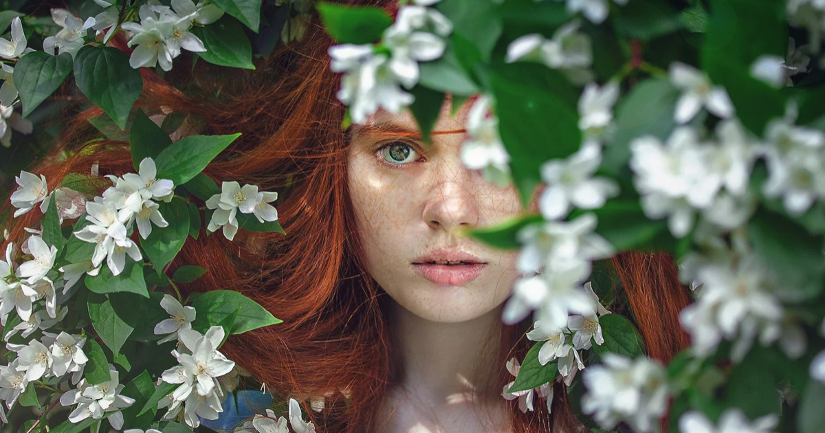 花の中にいる赤毛の女性